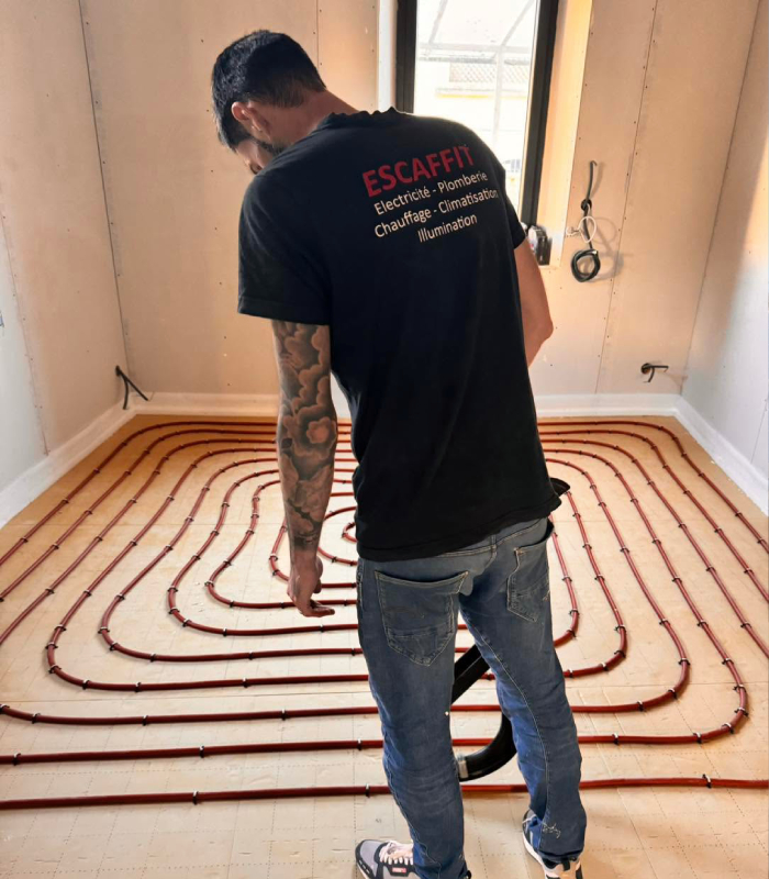 Technicien Société Escaffit installant un chauffage au sol dans une habitation